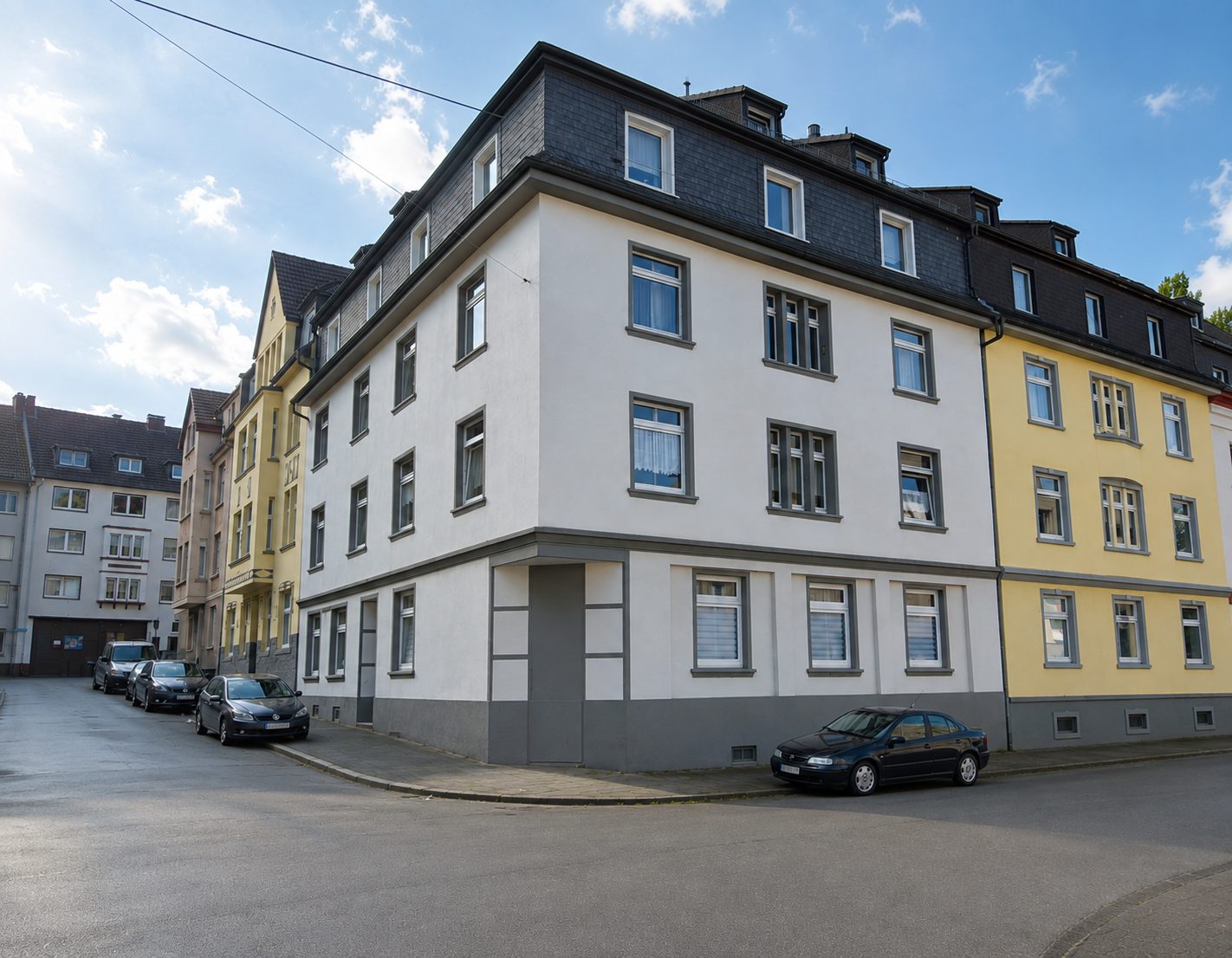 Weißes Eckhaus als Mehrfamilienhaus