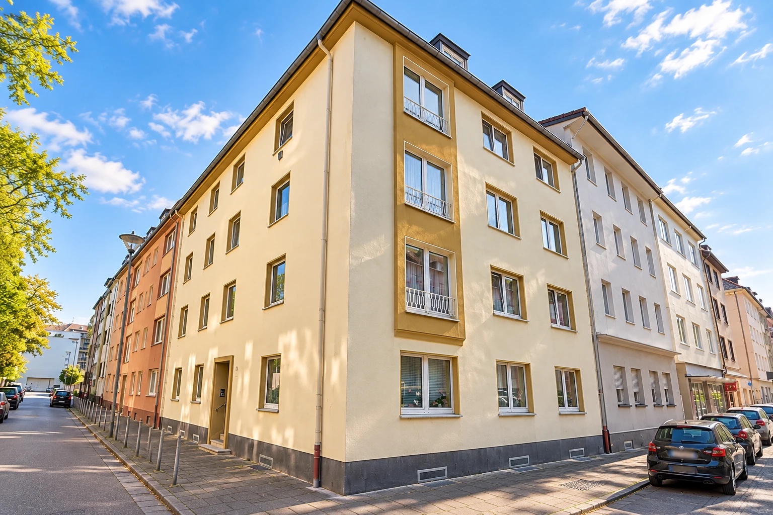 Gelbes Eckhaus als Mehrfamilienhaus an einer Straßenkreuzung