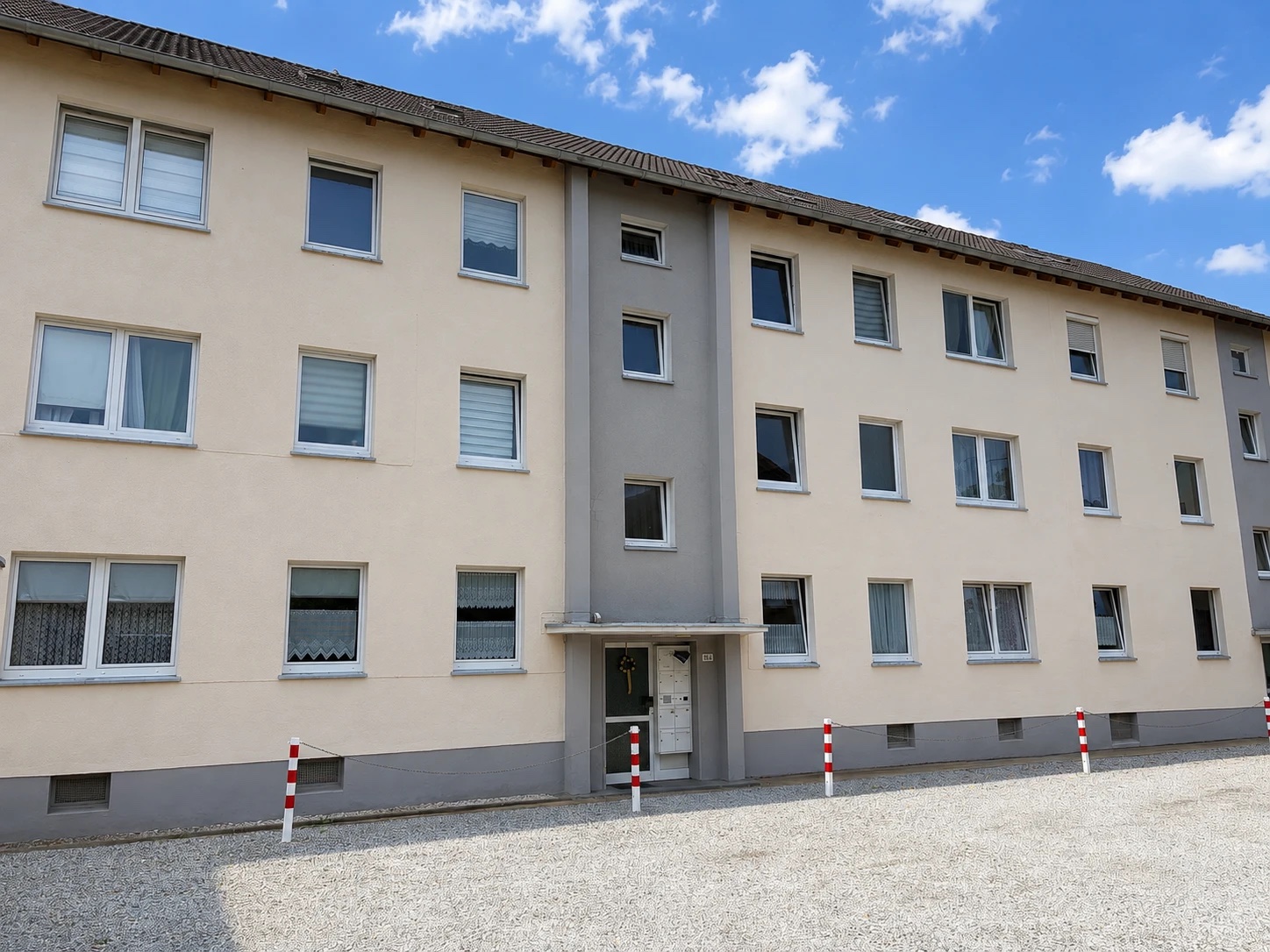 Langgestrecktes Mehrfamilienhaus mit heller Putzfassade