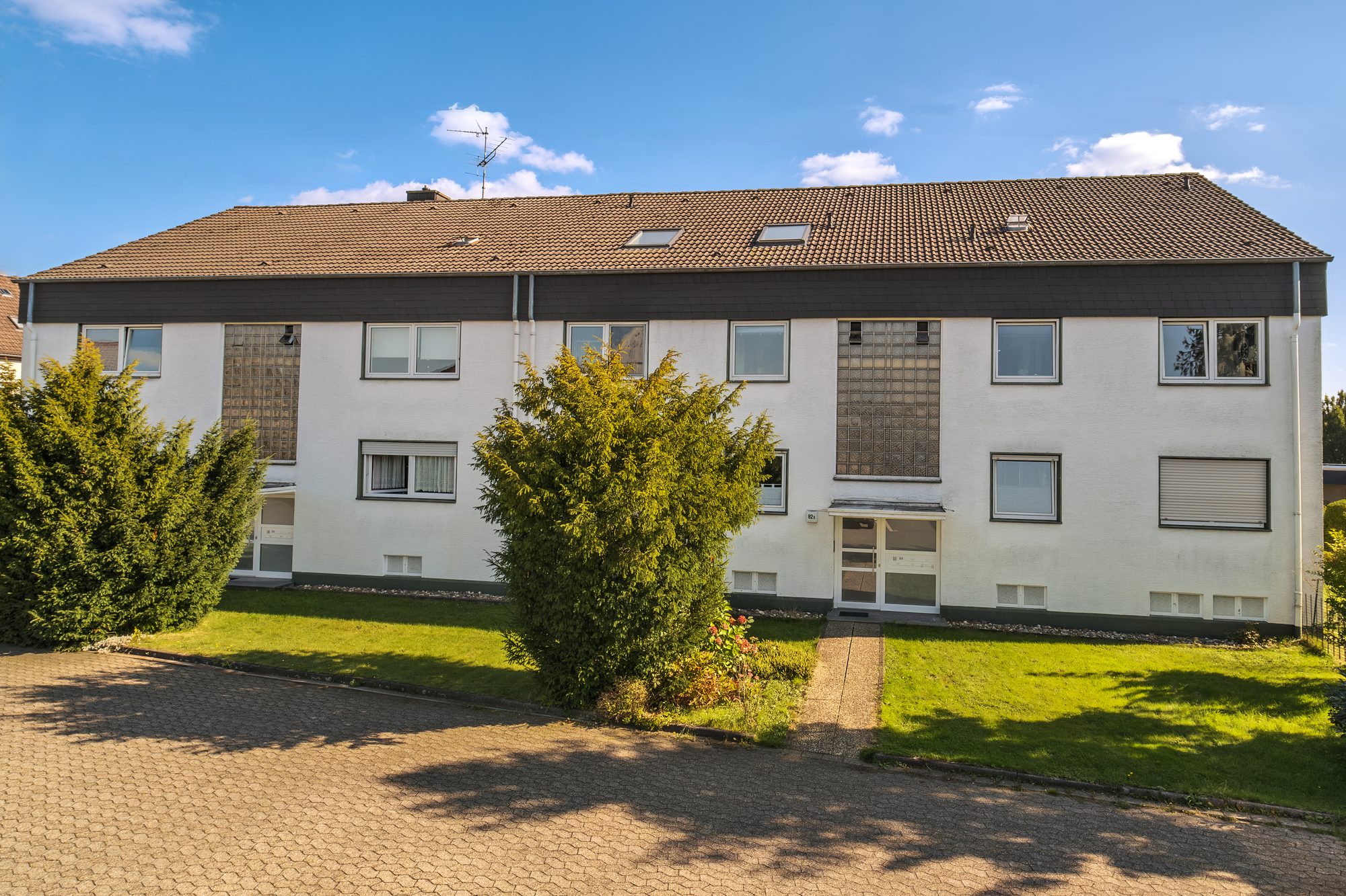 Langgestreckte Wohnanlage mit Satteldach und Grünflächen